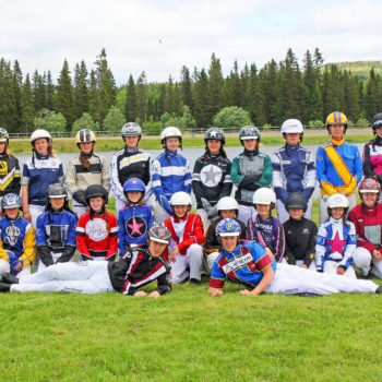 Gruppbild på deltagarna i ponnyelitveckan 2019. Ungdomarna har sina kuskdressar och hjälmar på sig
